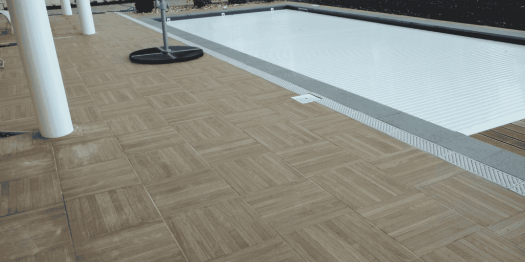Carrelage effet bois posé autour d'une piscine à volet immergé à Lescar