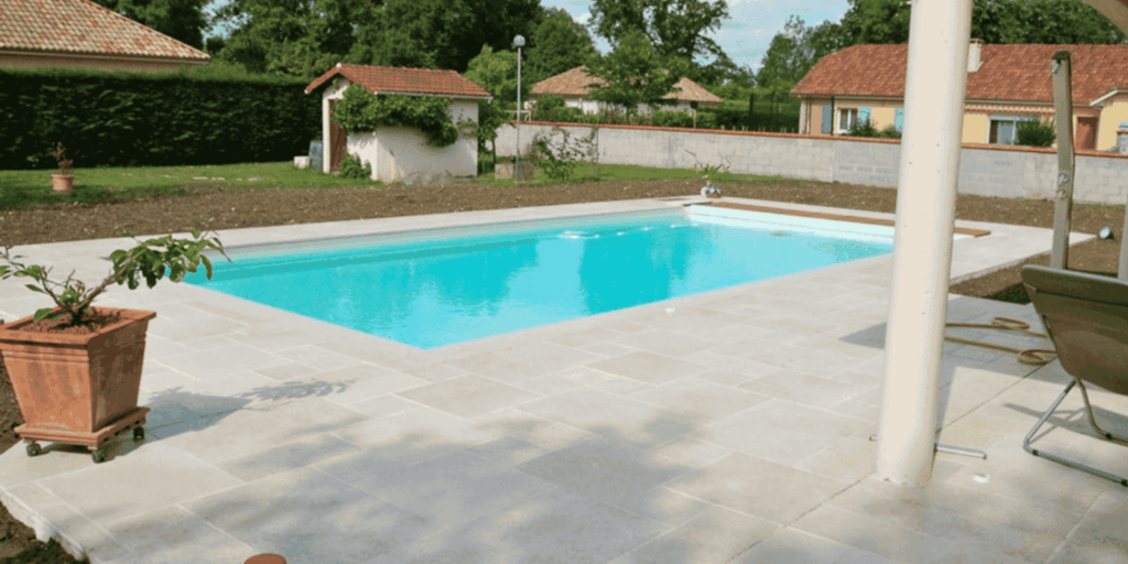 Carrelage pierre claire posé autour d'une piscine de jardin à Lescar