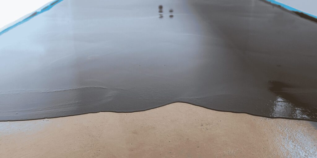 Coulage d'une résine autolissante gris foncé sur dalle béton à Serres-Castet