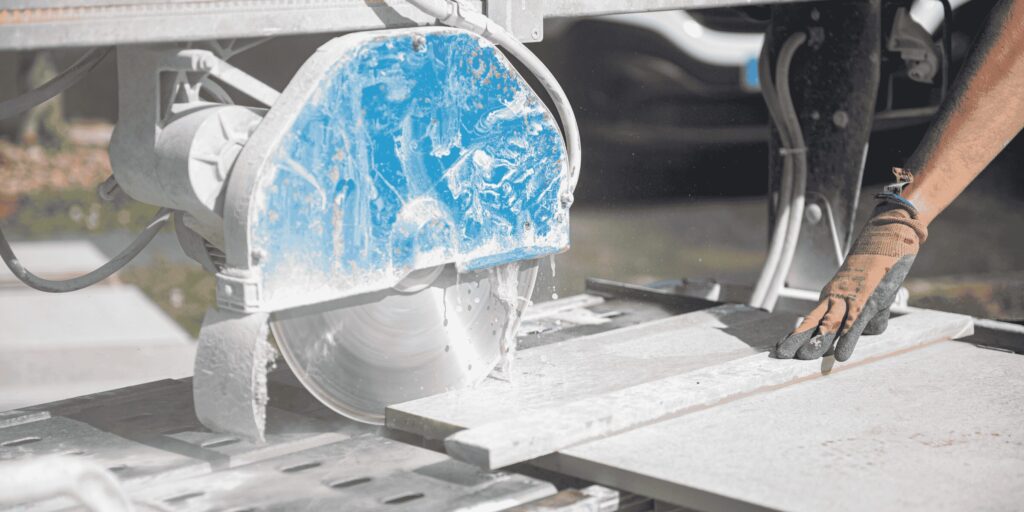 Découpe d'une dalle à la scie sur table lors d'un chantier sur plots à Serres-Castet