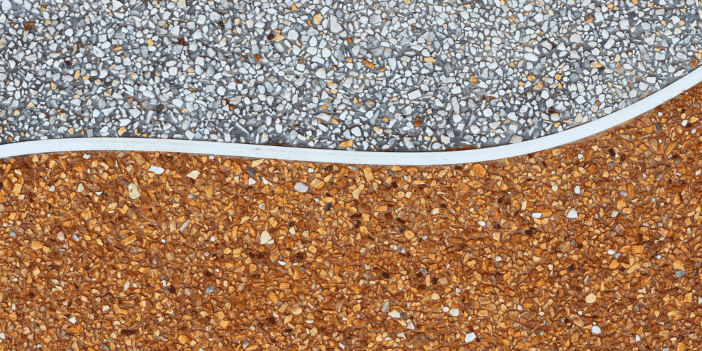 Détail d'une moquette de pierre bicolore gris et ocre séparée par un liseré courbe à Serres-Castet