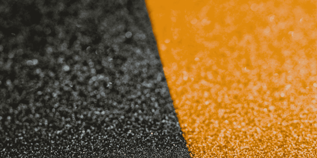 Détail rapproché de granulats noirs et orange pour moquette de pierre à Pau