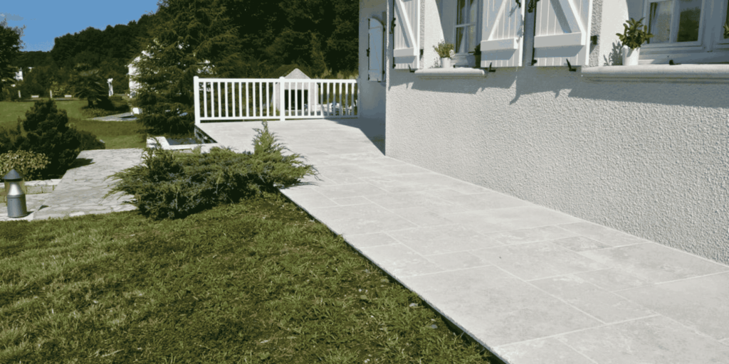 Pose de carrelage extérieur pierre claire le long d'une maison béarnaise à Lescar