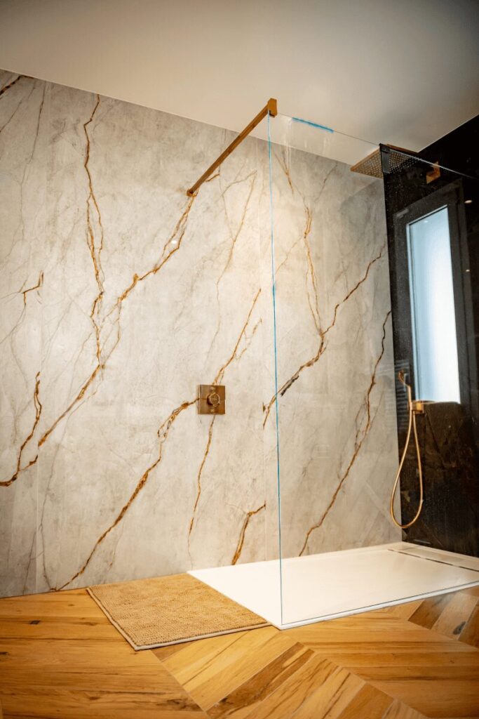 Pose de carrelage grand format effet marbre veiné dans une douche à l'italienne à Pau