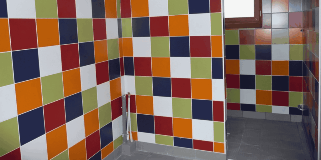 Pose de faïence murale multicolore dans des sanitaires à Pau